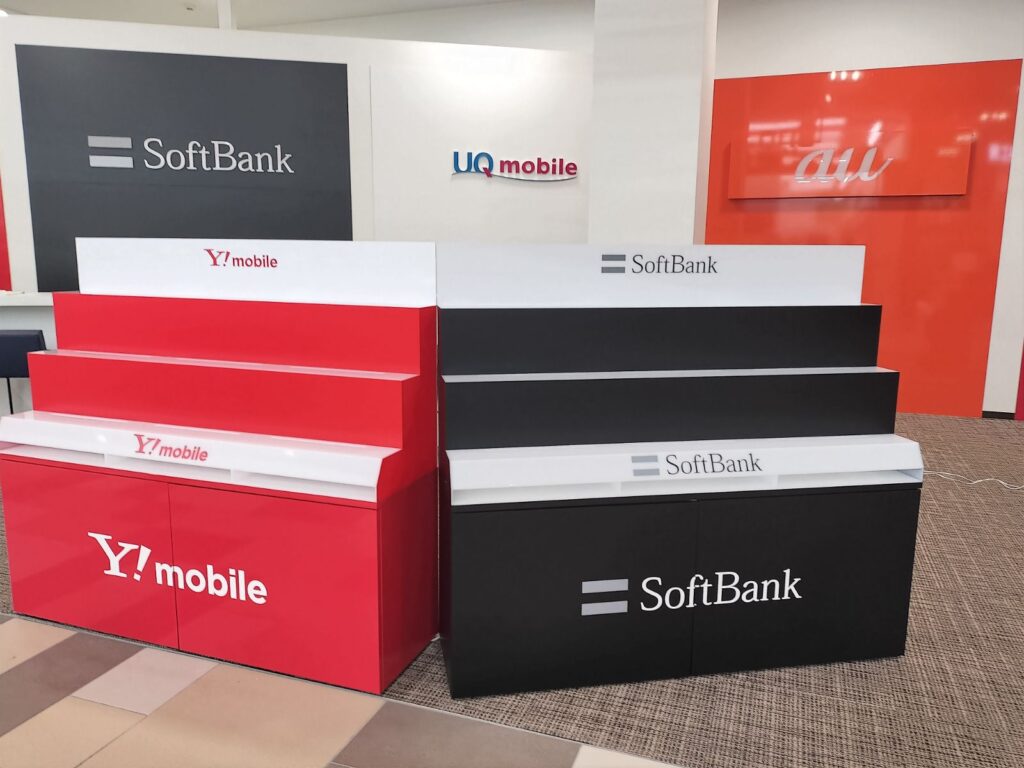 携帯ショップのキャリア別什器製作｜ブランドカラーシート×LED内照式アクリルひな壇